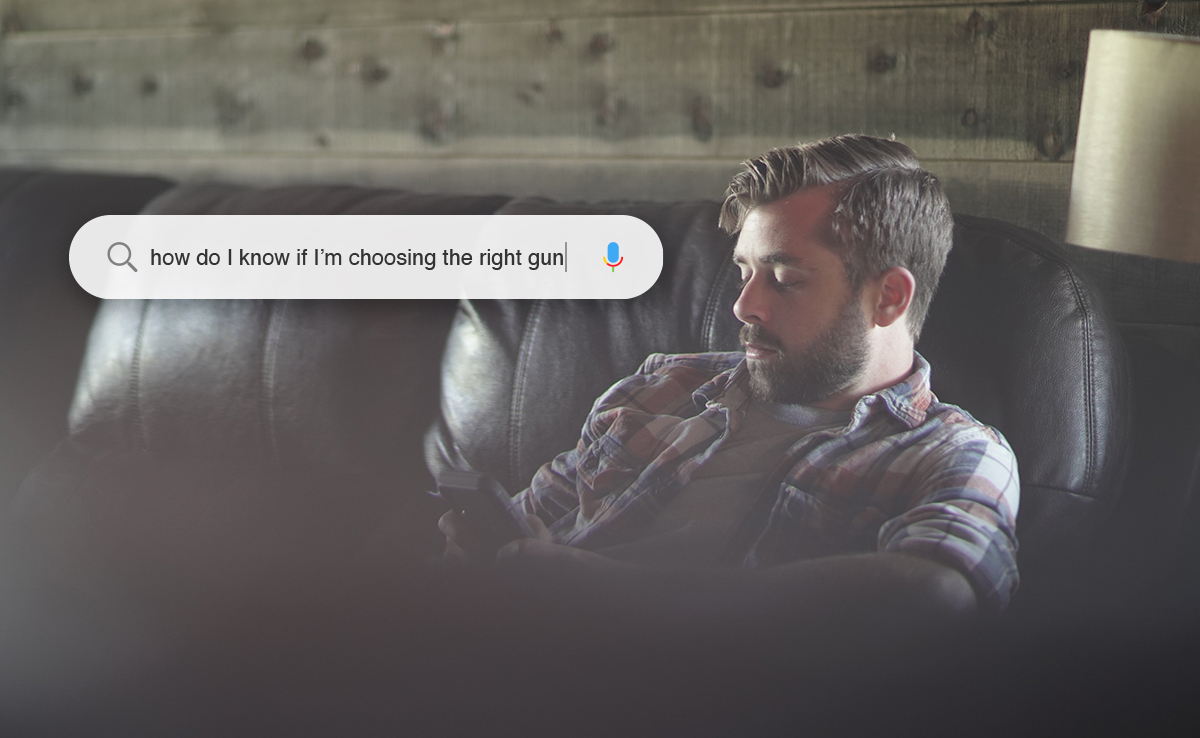 Man sitting on brown couch asking phone how do I know if I am choosing the right gun